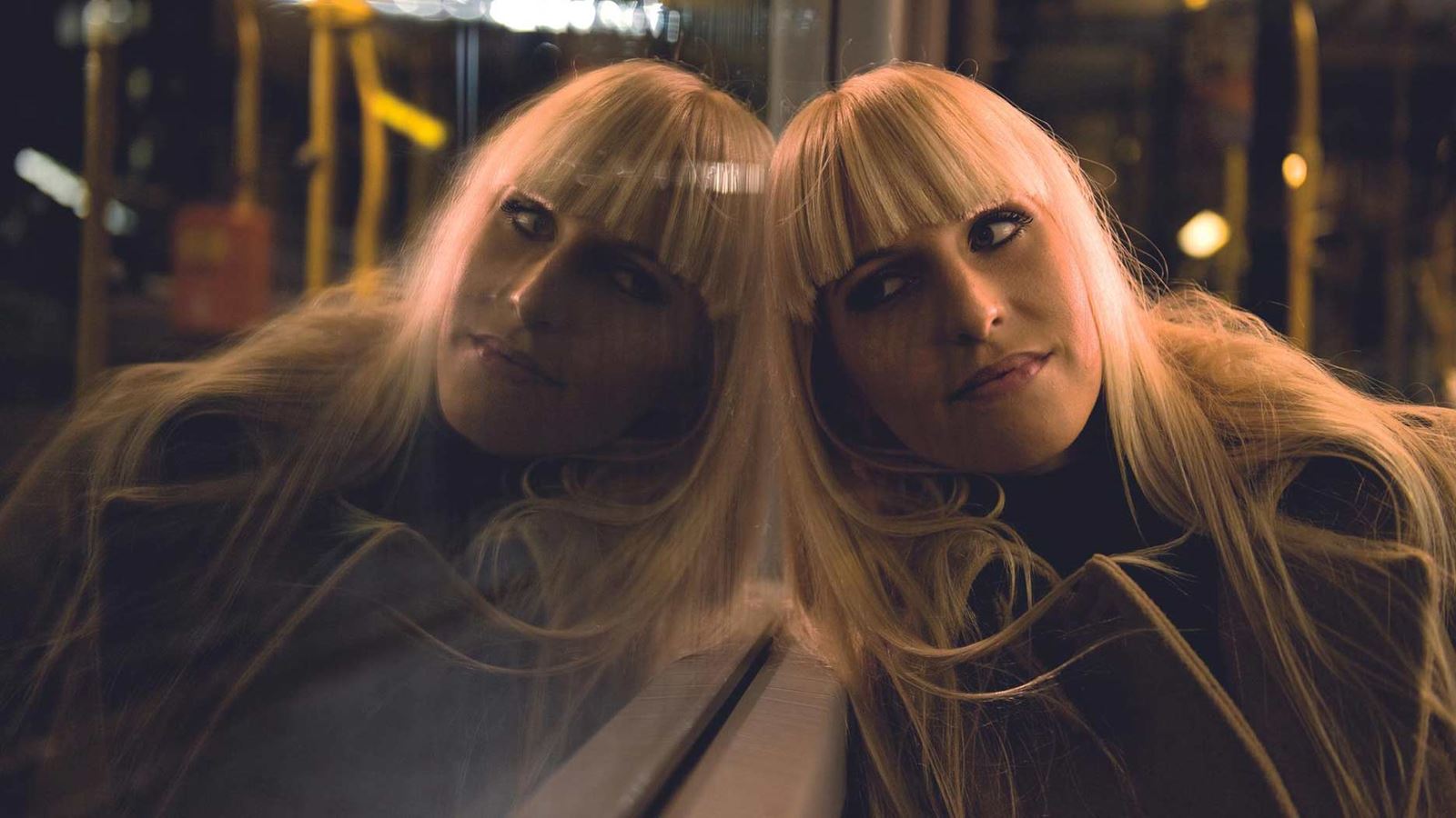 A young woman is on a night bus.