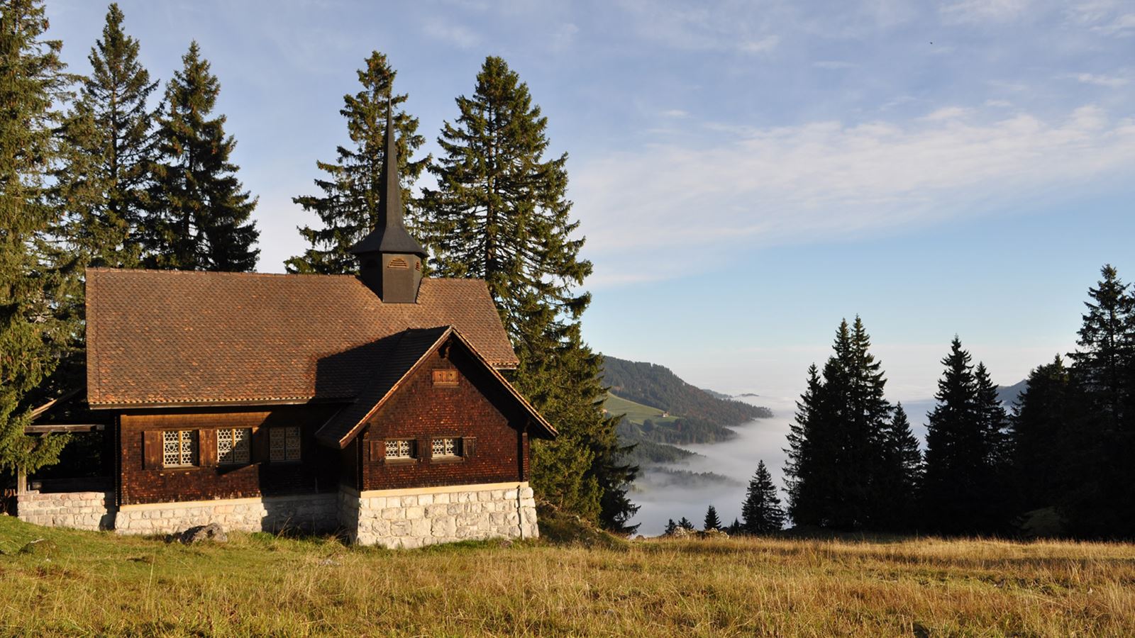 La cappella Holzegg nell’Alpthal con una splendida vista sulla valle coperta di nebbia.