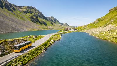Das Postauto fährt auf dem Flüelapass entlang.