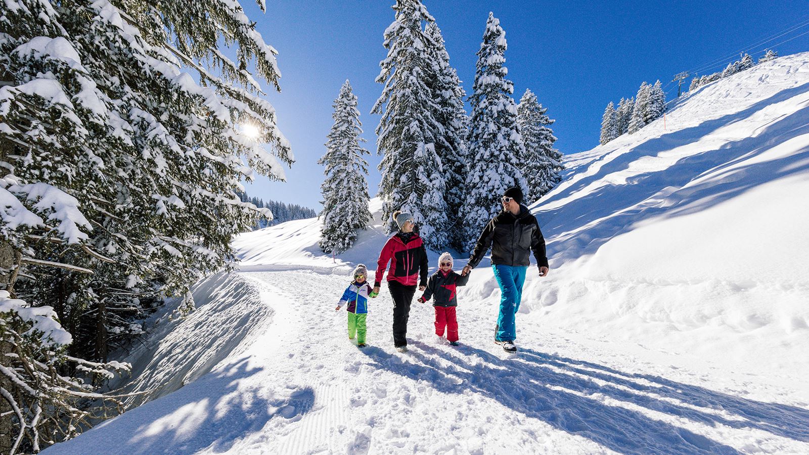 Familia beim Winterspaziergang im Schnee