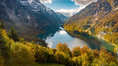 Le lac du Klöntal dans une ambiance automnale, entouré de montagnes enneigées.
