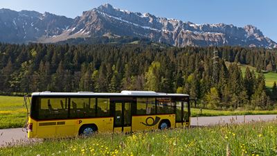 A Postbus against a mountain backdrop