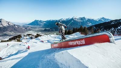 Un skieur en pleine action sur une rampe en haut d’une piste