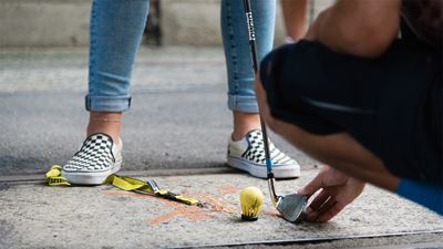 Close-up of feet and legs with yellow ball and racket on the Urban Golf Course in Winterthur.