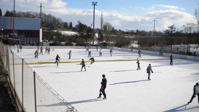 Des personnes patinent sur la surface de glace de Bülach, dans le centre sportif Hirslen.