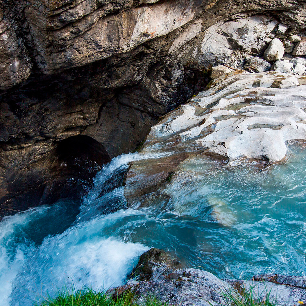 Gletscherwasser fliesst in der Gletscherschlucht über ein Tobel hinab.