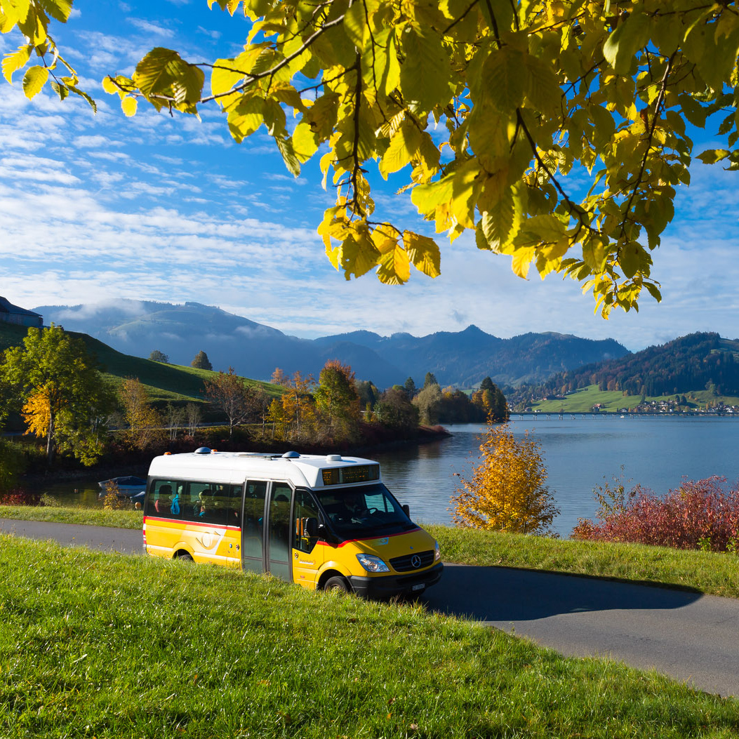 Regional passes – Postbus with Tell-Pass at Lake Sihl in Central Switzerland against an autumnal landscape