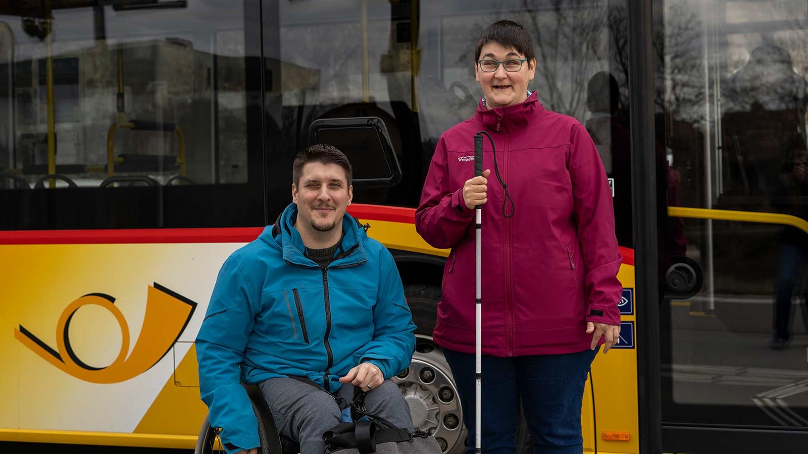 Louis Amport und Daniela Moser vor einem Postauto.