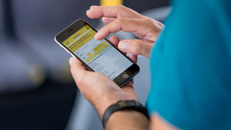 Close-up of a hand using the PostBus App.