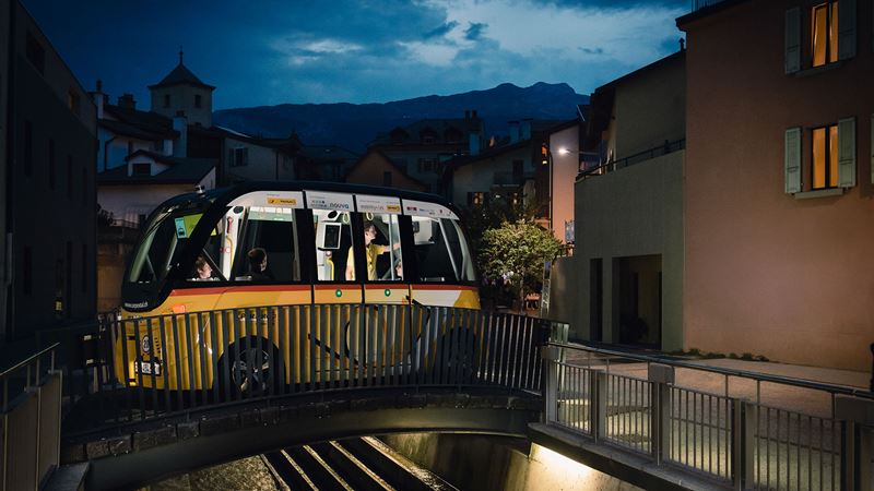 Der SmartShutlle von PostAuto fährt in der Nacht über eine kleine Brücke in Sion.