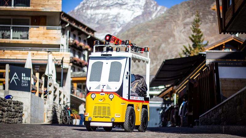 The PostBus luggage robot Robi, which is driving through Saas-Fee loaded with skis and suitcases.