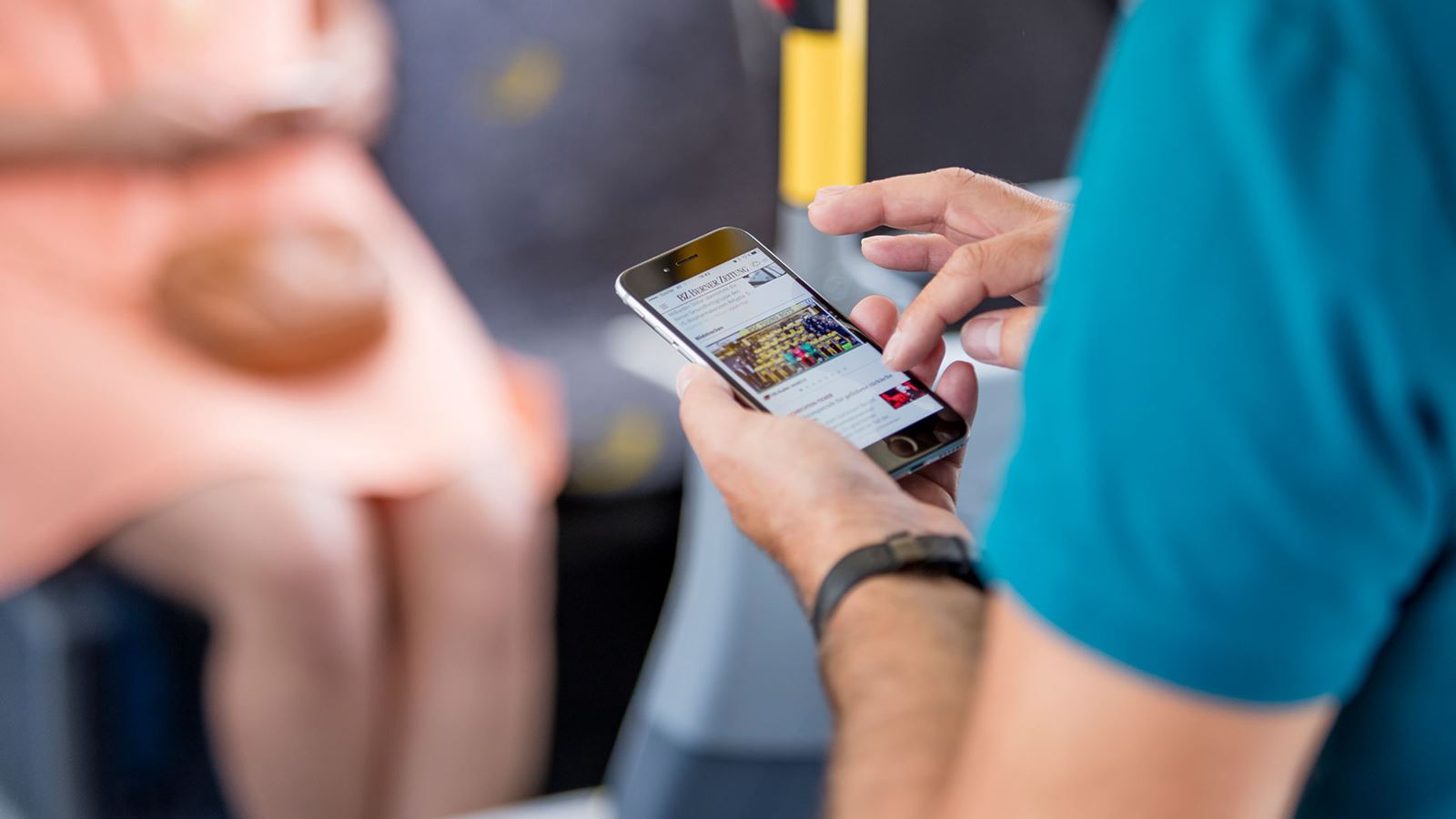 Ein Fahrgast surft auf seinem Handy im Wifi von PostAuto.