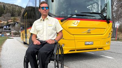 In der Region Savièse, wo er wohnt, sitzt David Dubuis im Rollstuhl, im Hintergrund steht sein Postauto.