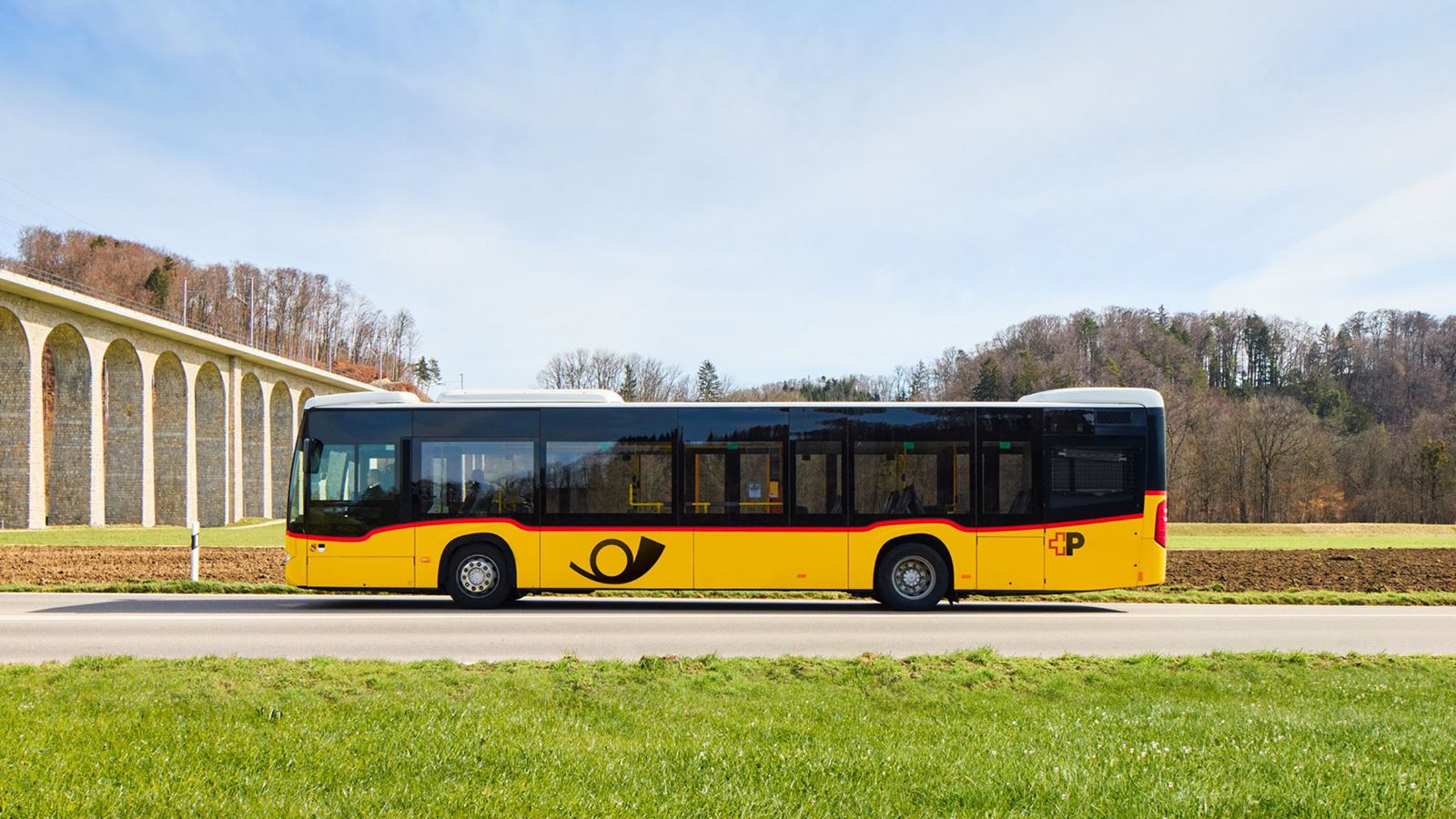 A Postbus with the new logo can be seen from the front.