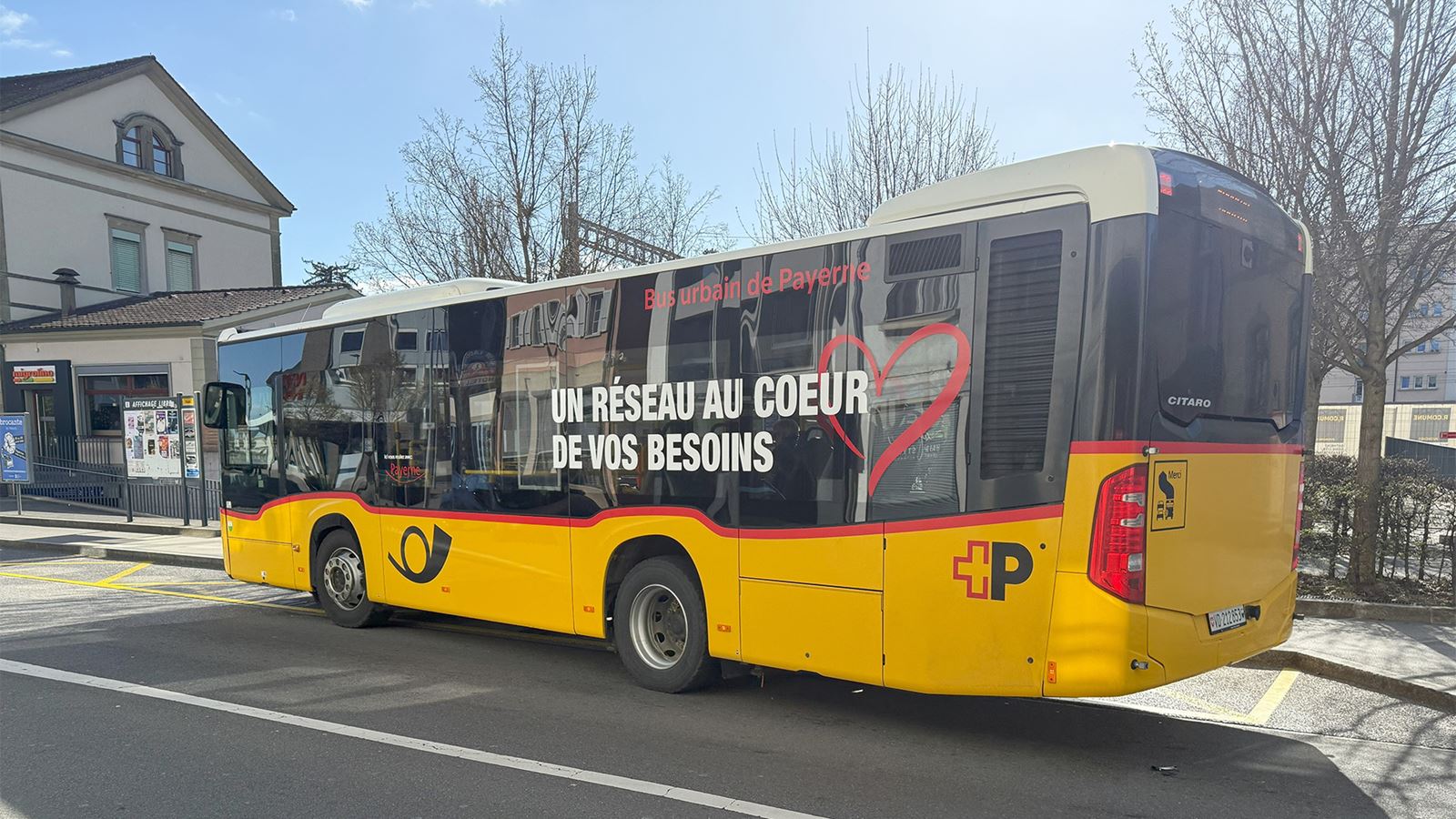 Un bus urbain de Payerne CarPostal parquer devant une gare